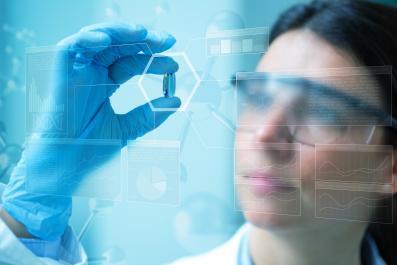 stock image of a female scientist looking at a pill